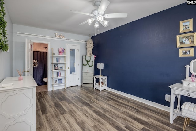 interior space featuring baseboards, ceiling fan, wood finished floors, and ensuite bath