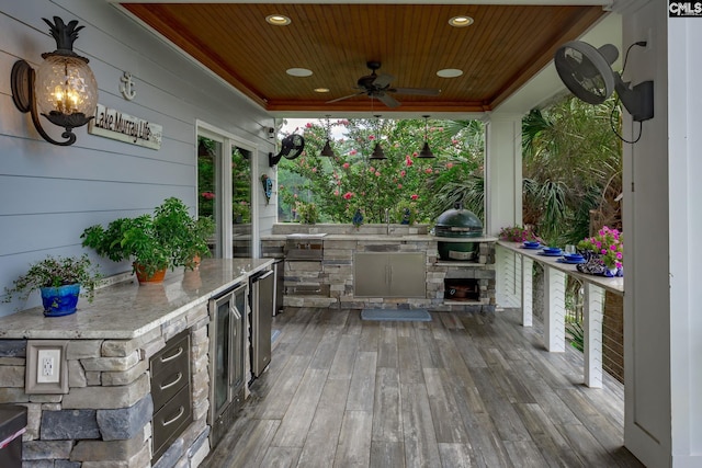 wooden deck with ceiling fan, a grill, and area for grilling