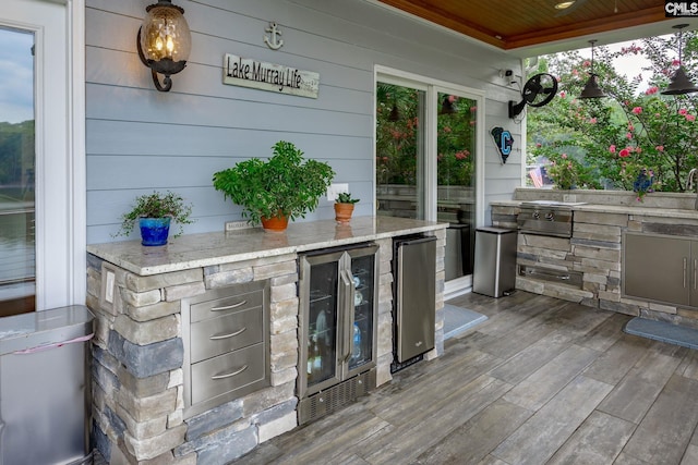 wooden terrace featuring wine cooler and an outdoor kitchen