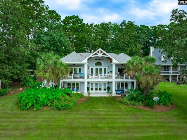 back of house featuring ceiling fan, french doors, a lawn, a balcony, and a patio