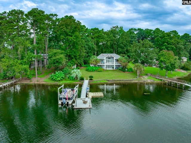 view of dock with boat lift, a water view, and a yard