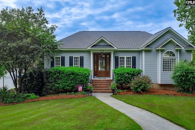 view of front of house featuring a front lawn and roof with shingles