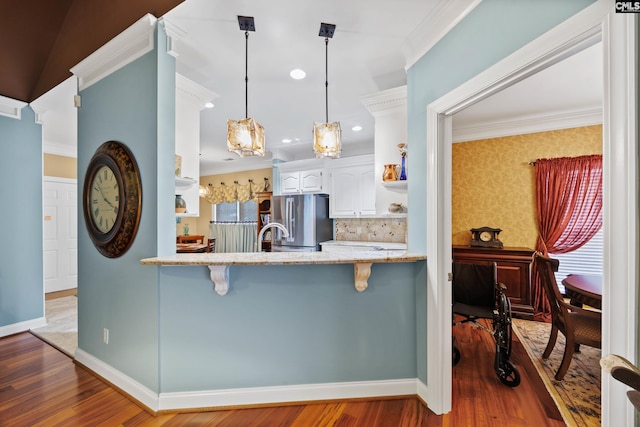 kitchen featuring white cabinets, open shelves, light stone counters, freestanding refrigerator, and wood finished floors