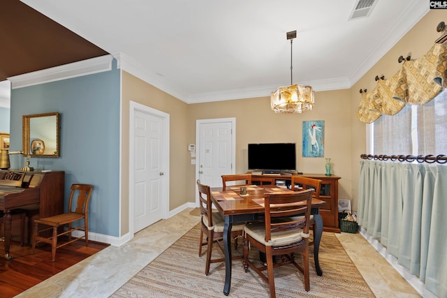 dining space with visible vents, ornamental molding, baseboards, and a chandelier