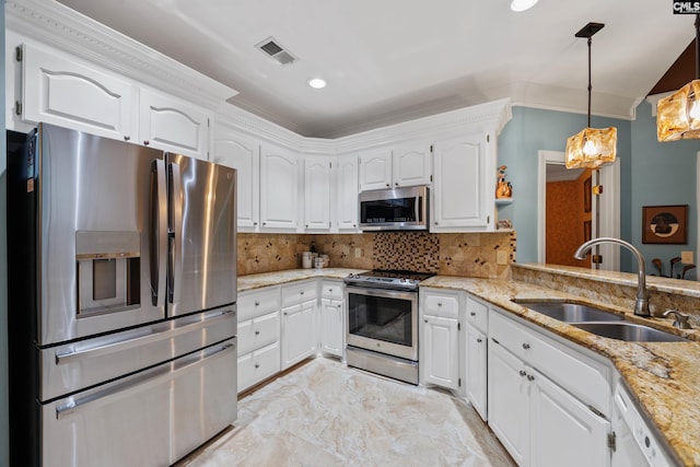 kitchen with white cabinets, appliances with stainless steel finishes, light stone counters, a sink, and visible vents