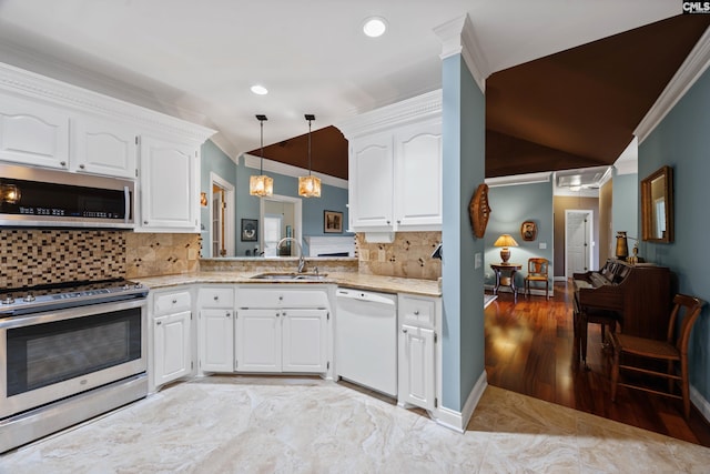 kitchen with light stone countertops, vaulted ceiling, a sink, ornamental molding, and stainless steel appliances