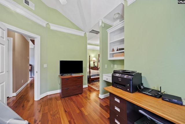 office space with ornamental molding, vaulted ceiling, wood finished floors, and visible vents