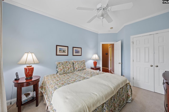 bedroom featuring crown molding, light carpet, a ceiling fan, baseboards, and a closet