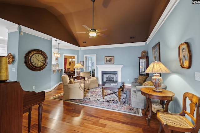 living area featuring crown molding, ceiling fan with notable chandelier, hardwood / wood-style flooring, and lofted ceiling