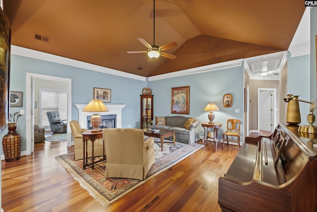 living area featuring ceiling fan, attic access, visible vents, wood finished floors, and lofted ceiling