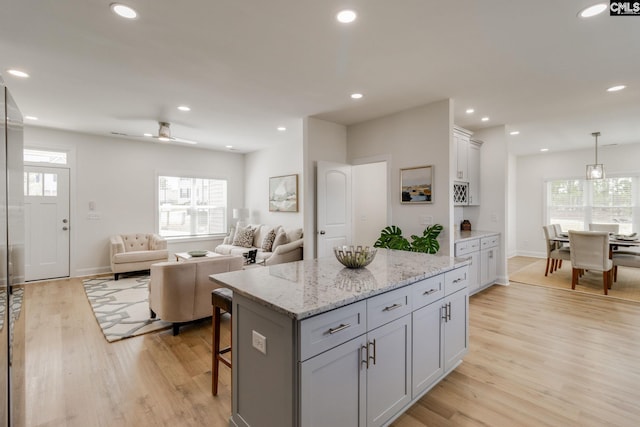 12 Magnolia Bay Ct, Columbia, SC 29229 - kitchen with a breakfast bar, a center island, light wood finished floors, recessed lighting, and light stone countertops