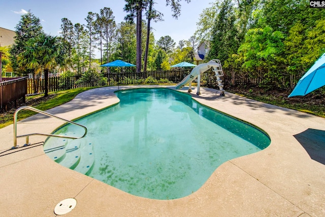 view of pool featuring a fenced backyard, a fenced in pool, a water slide, and a patio
