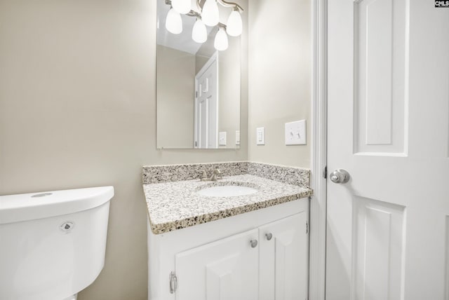 half bath featuring vanity and toilet