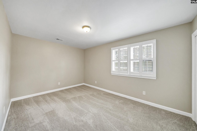 unfurnished room with carpet flooring, baseboards, and visible vents