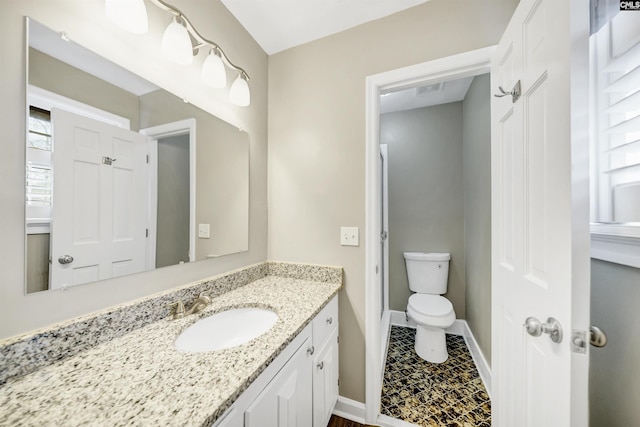 bathroom with toilet, baseboards, visible vents, and vanity