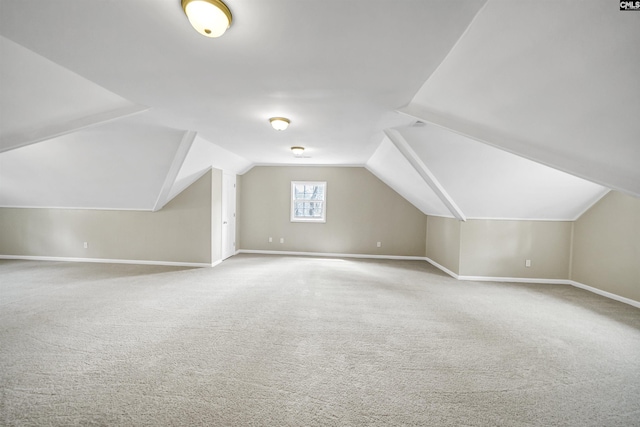 additional living space with baseboards, carpet flooring, and lofted ceiling