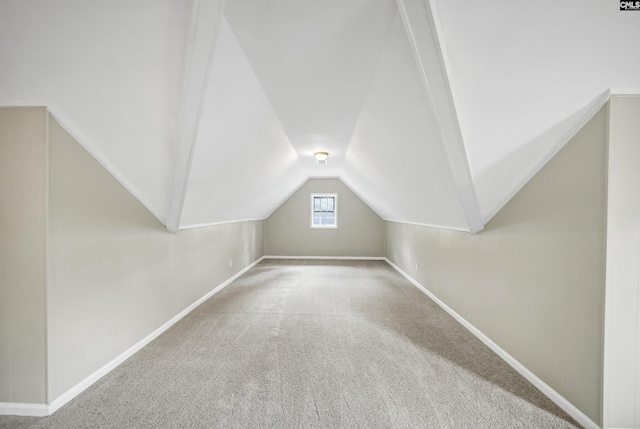 additional living space with carpet floors, baseboards, and vaulted ceiling