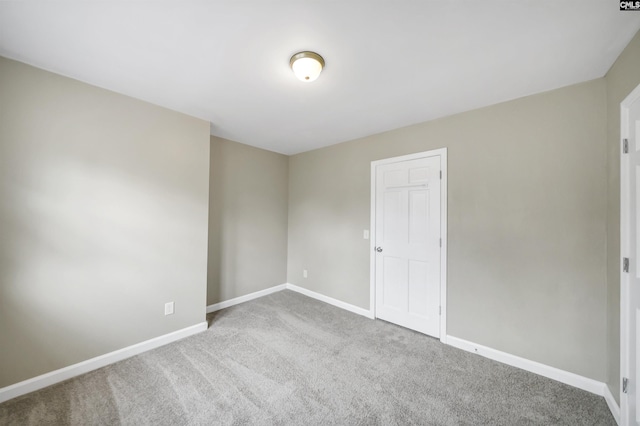 carpeted empty room featuring baseboards