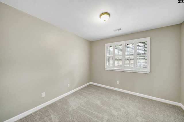 carpeted empty room with visible vents and baseboards
