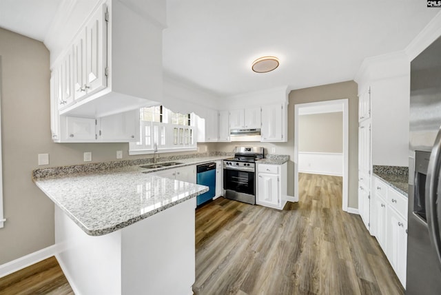 kitchen with appliances with stainless steel finishes, a peninsula, white cabinetry, wood finished floors, and under cabinet range hood