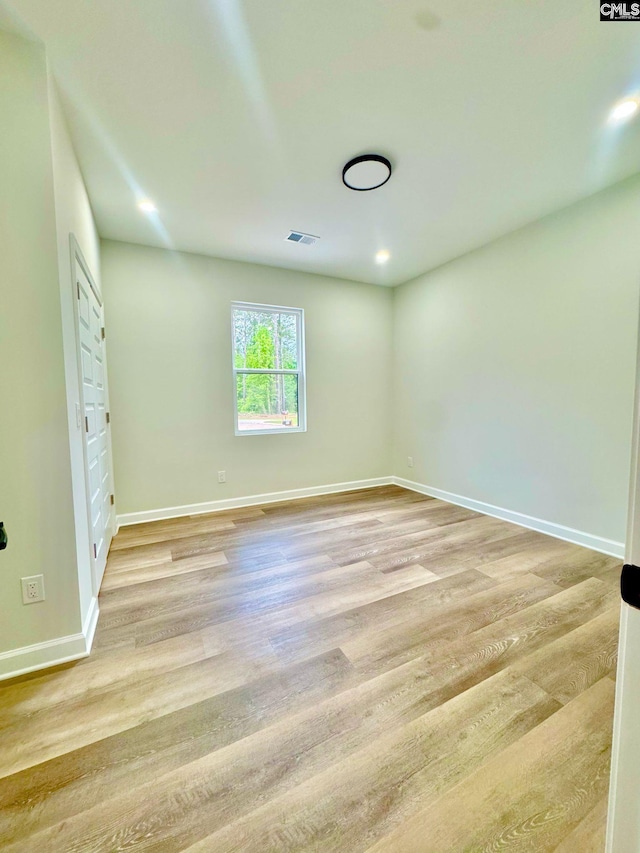 unfurnished bedroom featuring baseboards, light wood finished floors, and visible vents