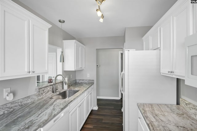 kitchen with white dishwasher, light stone countertops, a sink, white cabinetry, and dark wood-type flooring