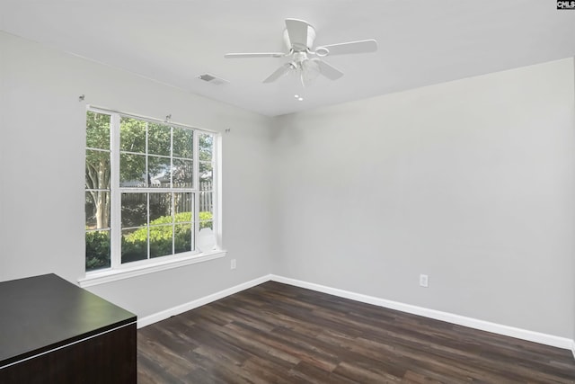 unfurnished room with baseboards, visible vents, dark wood-style floors, and ceiling fan
