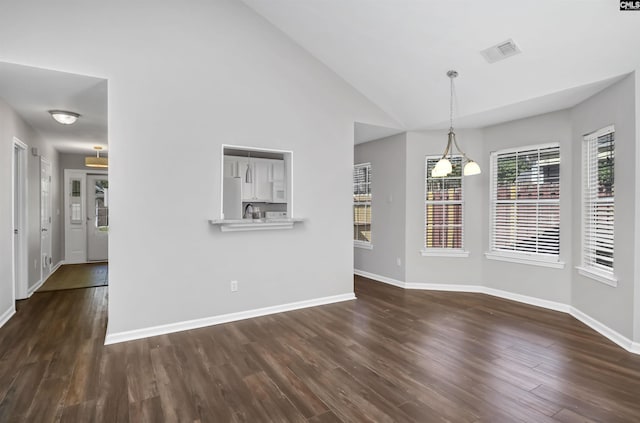 unfurnished dining area featuring baseboards, dark wood-type flooring, lofted ceiling, and visible vents