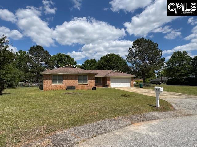 single story home featuring fence, an attached garage, concrete driveway, and a front lawn