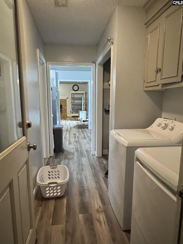 40 Turn Row Ct, Sumter, SC 29154 - clothes washing area featuring washer and clothes dryer, a textured ceiling, wood finished floors, and cabinet space