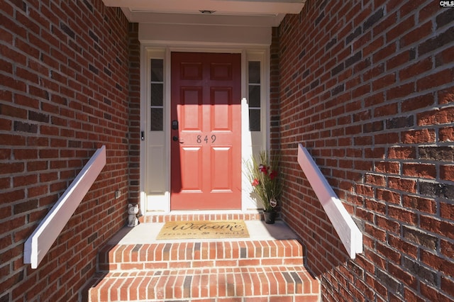 view of exterior entry featuring brick siding