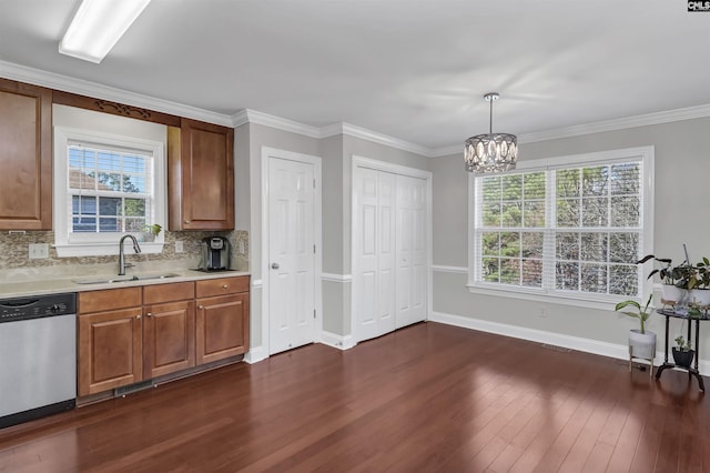 kitchen featuring stainless steel dishwasher, dark wood-type flooring, light countertops, tasteful backsplash, and a sink