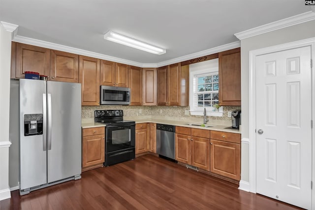 kitchen with light countertops, stainless steel appliances, a sink, and dark wood-type flooring