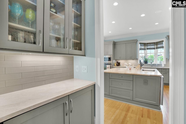 119 Ashley Trace Dr, Lexington, SC 29072 - bar featuring appliances with stainless steel finishes, light wood-style flooring, recessed lighting, decorative backsplash, and ornamental molding