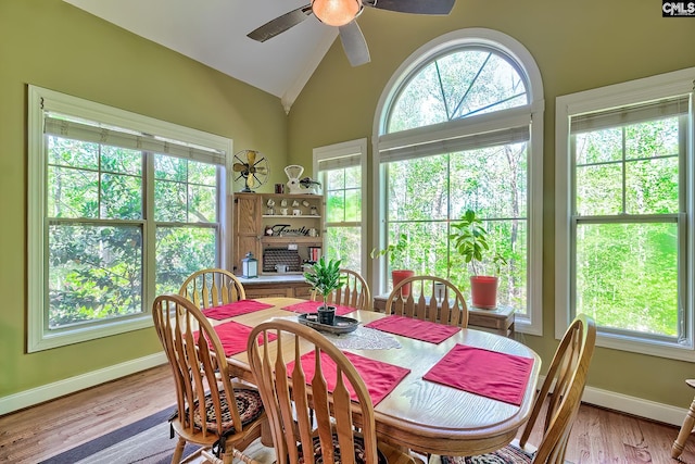 dining area featuring a ceiling fan, baseboards, light wood-style flooring, and lofted ceiling