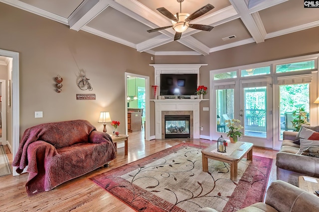 living area with ceiling fan, coffered ceiling, wood finished floors, and visible vents