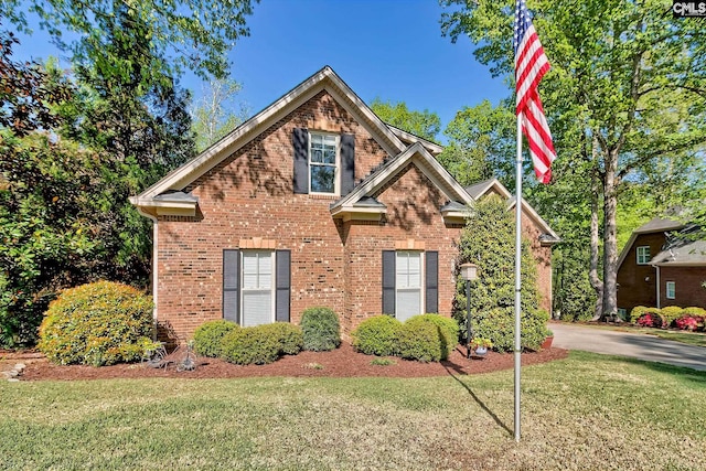 view of front of property with brick siding and a front lawn