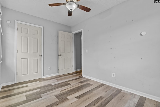 unfurnished bedroom featuring baseboards, a ceiling fan, and light wood-style flooring
