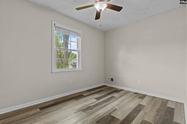 unfurnished room with visible vents, wood finished floors, baseboards, a textured ceiling, and a ceiling fan