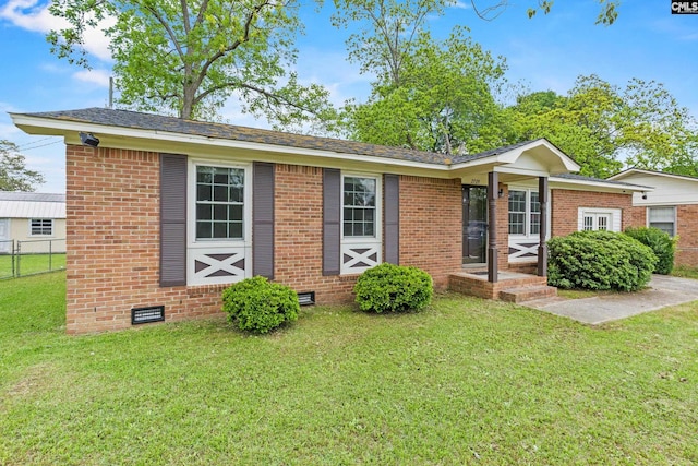 single story home with brick siding, fence, a front yard, and crawl space