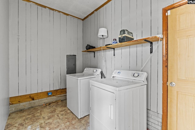 clothes washing area with crown molding, laundry area, separate washer and dryer, wood walls, and electric panel
