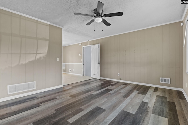 spare room featuring ceiling fan, wood finished floors, and visible vents