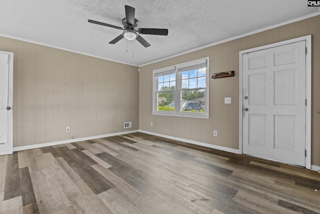 spare room featuring a ceiling fan, ornamental molding, and wood finished floors