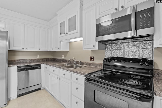 kitchen with a sink, dark countertops, white cabinets, and stainless steel appliances