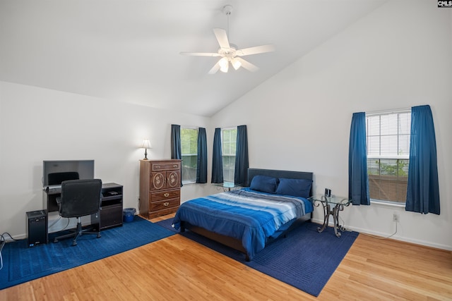 bedroom featuring high vaulted ceiling, multiple windows, baseboards, and wood finished floors
