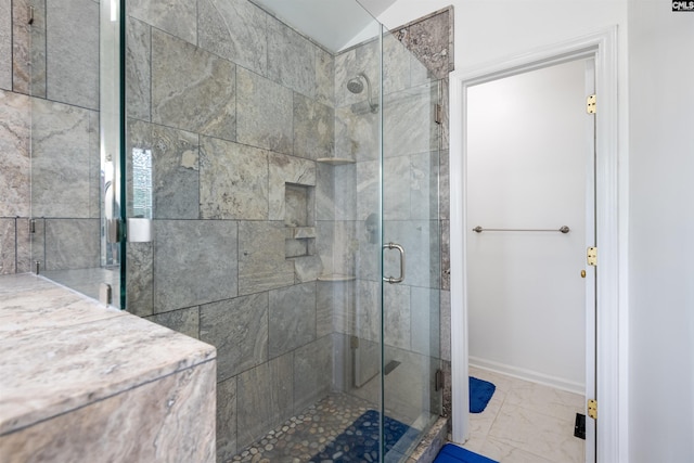 bathroom with baseboards, marble finish floor, and a stall shower
