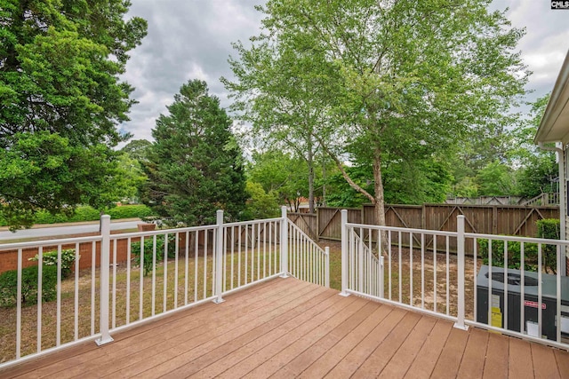 wooden terrace with a fenced backyard and a lawn