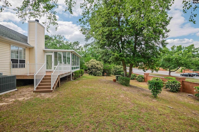 view of yard featuring a sunroom, central AC, and stairway
