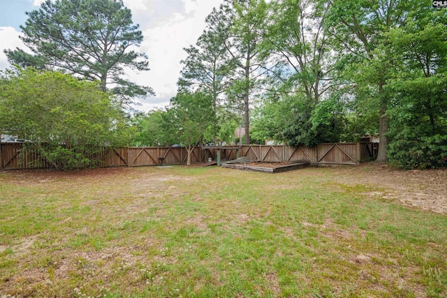 view of yard featuring a fenced backyard and a gate