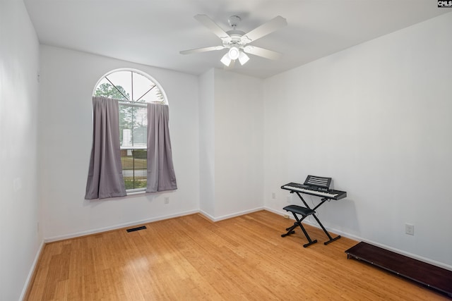 empty room featuring baseboards, ceiling fan, wood finished floors, and visible vents